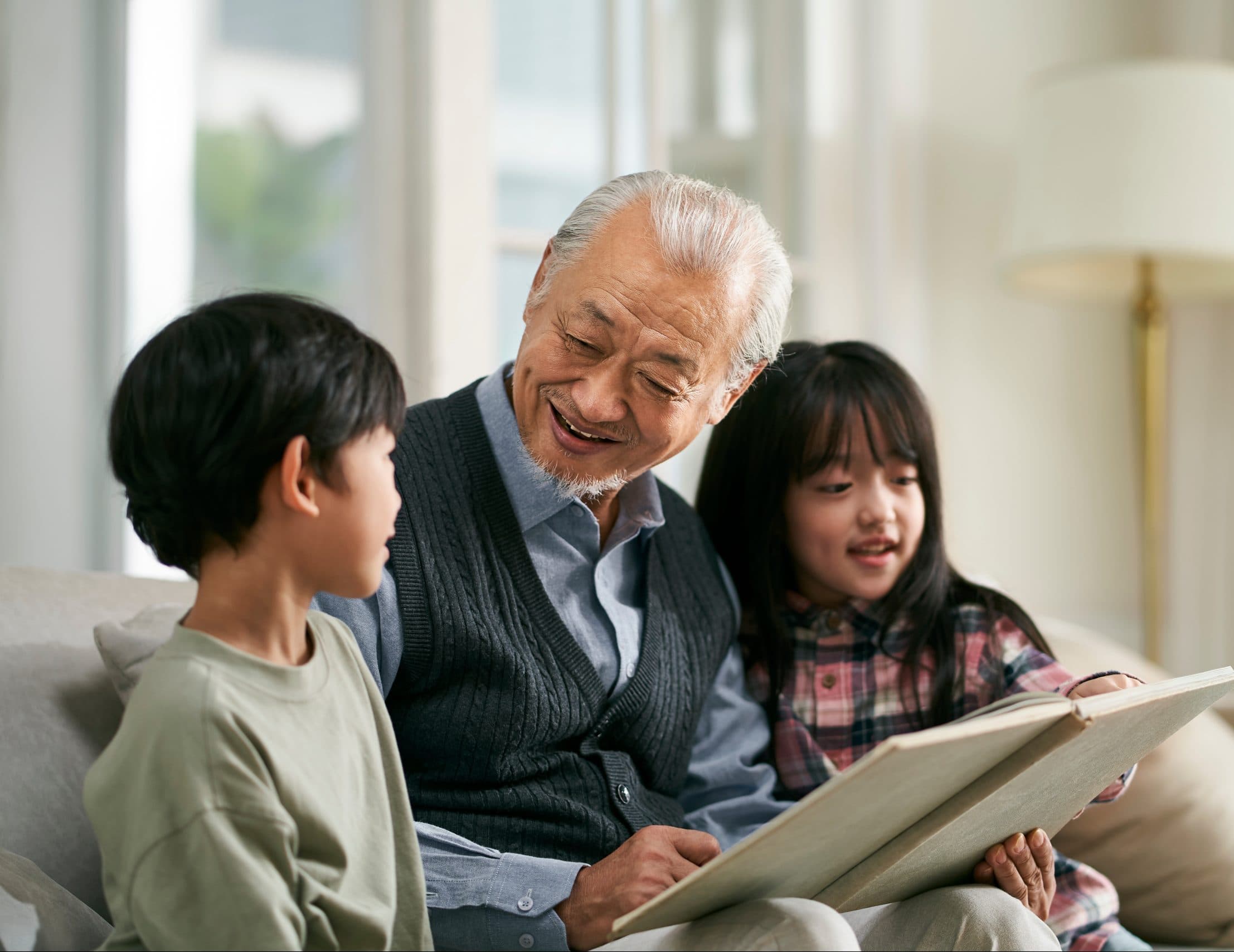 asian grandpa and two grandchildren having a good time at home