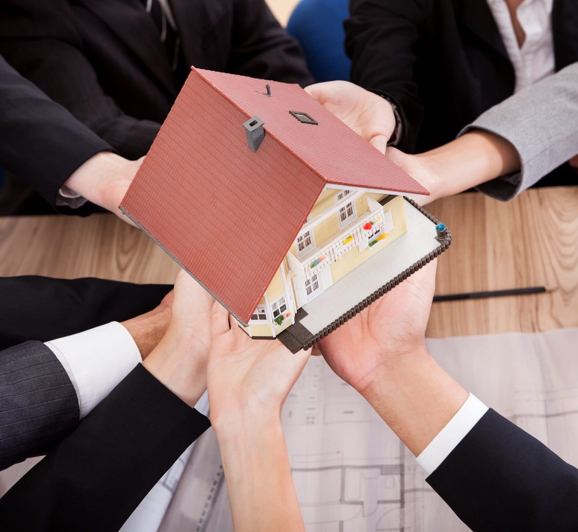 hands holding a house together, representing the concept of joint tenancy with right of survivorship in estate planning